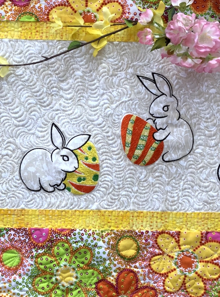 Close-up of the quilting pattern, Easter bunny and eggs embroidery on the tablerunner.