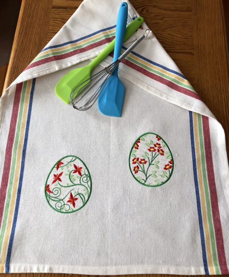 Egg designs embroidered as regular embroidery on a kitchen towel.