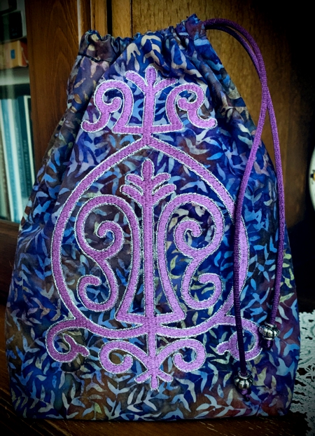 Finished purple bag with purple embroidery.