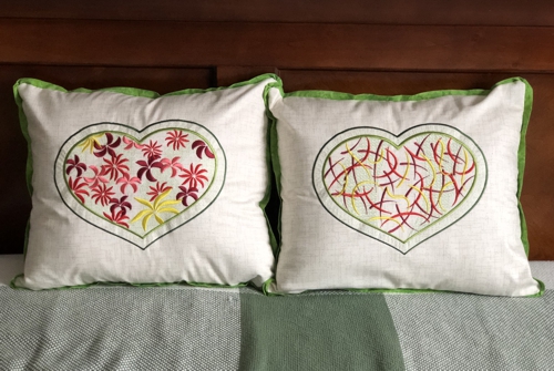 2 pillows with heart design embroidery.