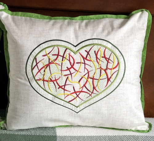 Finished pillow with heart design embroidery.