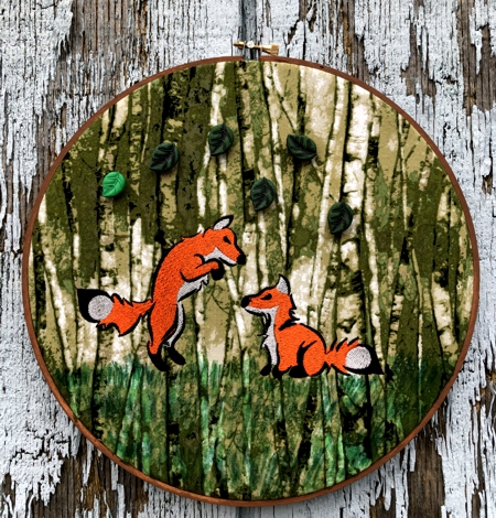 Hoop with the stitch-out of the playing foxes.
