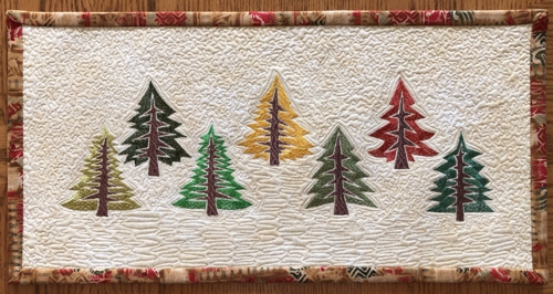 Finished quilt with pine tree embroidery