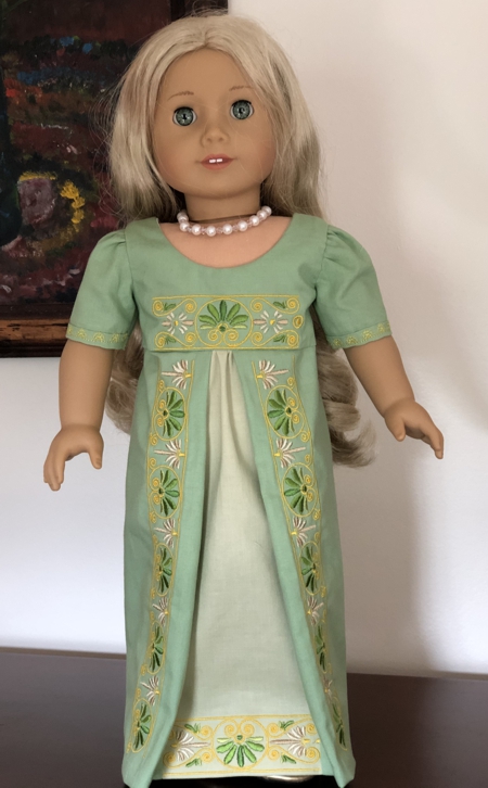 Finished sage colored dress on a doll.