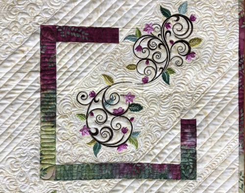 Quilted tablerunner with floral machine embroidery.Close-up pf the central part.