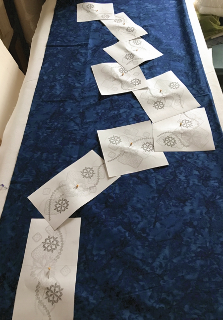 A piece of fabric with the paper print-outs of the designs.