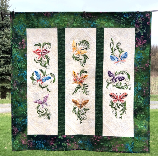 Finished wall quilt with butterfly embroidery.
