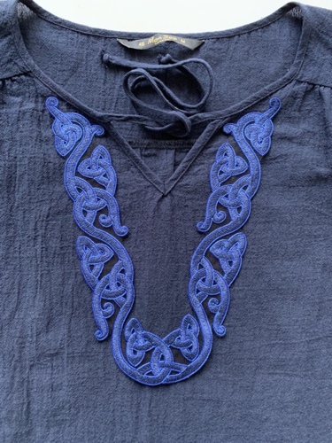 Embroidery of the Celtic design appliqued on a woman's blouse