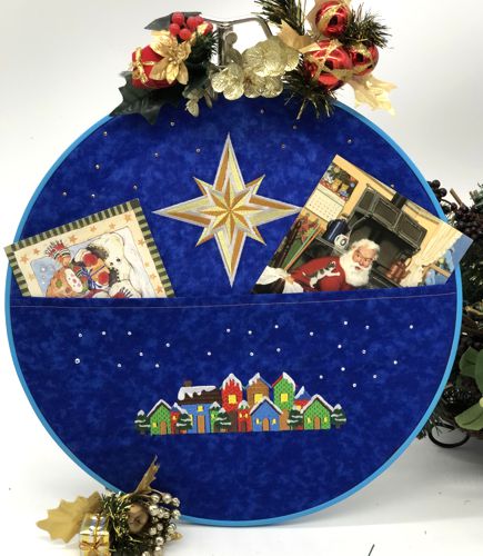 Card holder in an embroidery frame with Christmas-themed embroidery