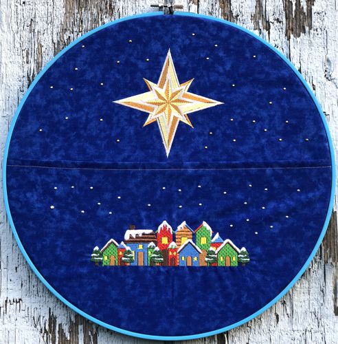Card holder in an embroidery frame with Christmas-themed embroidery