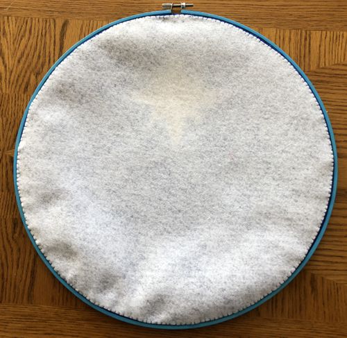 Cover the back with the felt circle and stitch it to the fabric along the edges