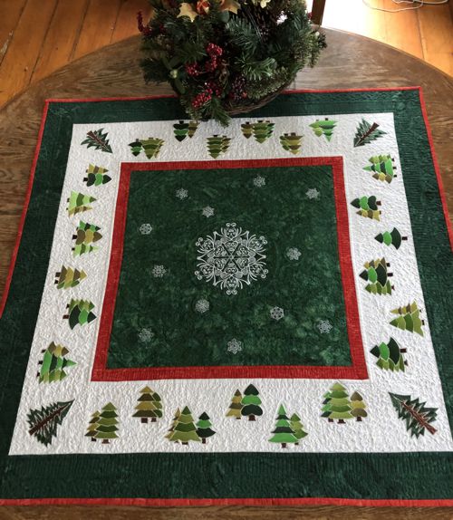 Finished quilted table topper with snowflake and pine tree embroidery