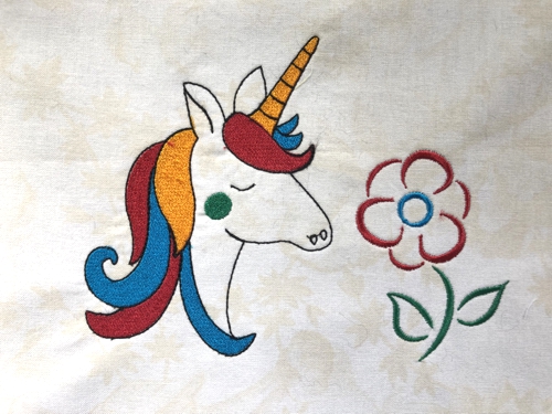 Embroidery of a unicorn and flower.