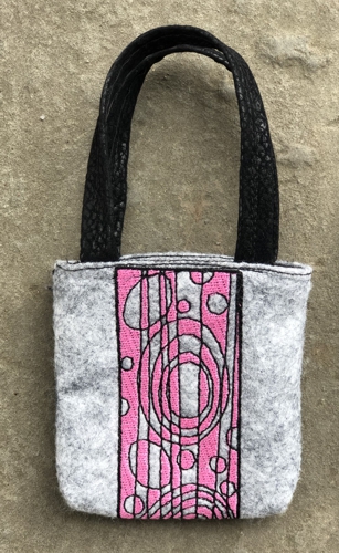 FInished gray felt bag with pink embroidery.