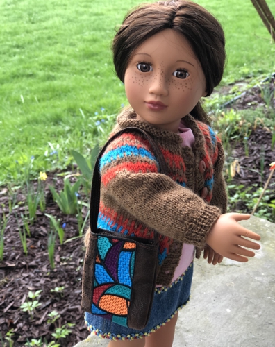 A doll with the shoulder bag made out of bookmark stitch-out.