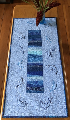 Finished quilted tablerunner with playing dolphin embroidery