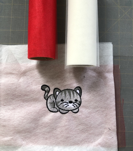 Embroidery of a kitten on the "sandwich" of netting and water-soluble mesh.