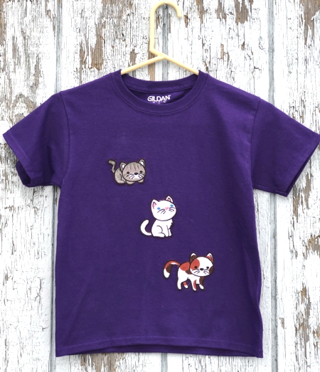 A kid's t-shirt decorated with kitten embroidery