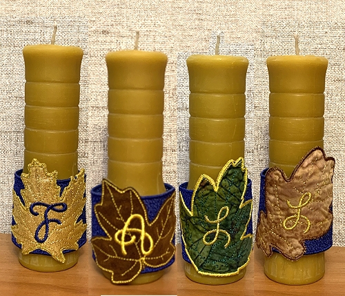 4 candles with decorative embroidered belts