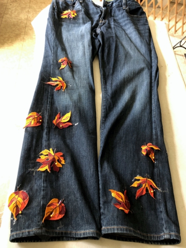 Stitch-outs of leaves pinned to jeans