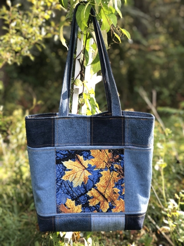 Finished tote bag with embroidery of maple leaves on the front panel.
