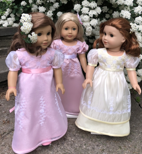 3 dolls in finished dresses with embroidery on bodice and skirt.