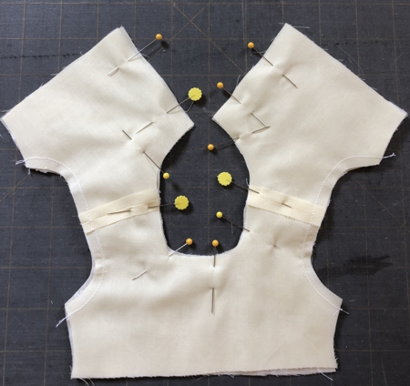 Pin the bodice lining and bodice together along the neck edge and back opening.