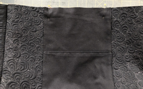 Position the raw edge of the pocket on the raw edge of the back panel on equal distance from the sides.