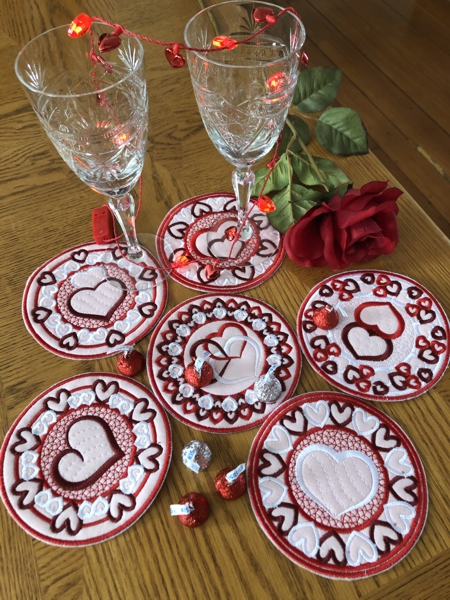 Finished Valentine Coasters on a table with glasses, candies and flowers