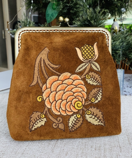 Finished purse with zinnia flower embroidery and metal frame.
