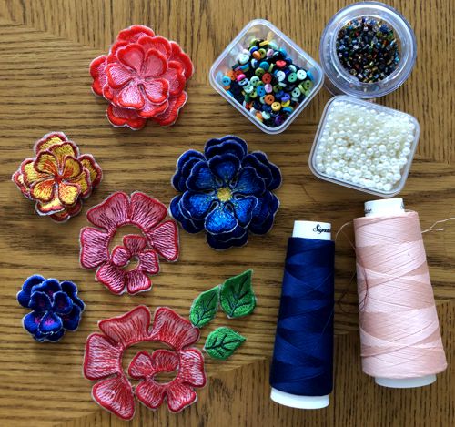 stitch-outs of the flowers, thread cones, boxes with buttons and beads.