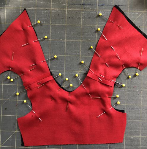 Pin the bodice lining and bodice together along the neck edge, back opening, and armholes.