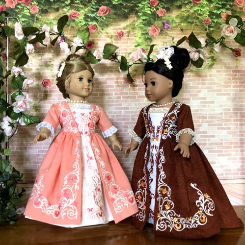 Photo of two 18-inch dolls modelling the formal colonial dress decorated with the machine embroidery