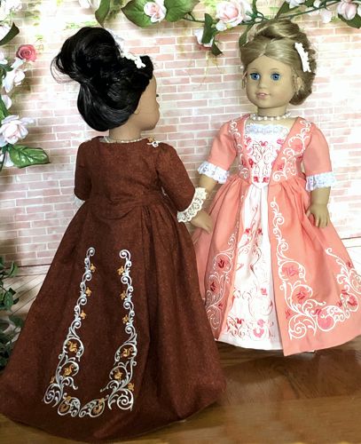 Photo of two 18-inch dolls modelling the formal colonial dress decorated with the machine embroidery