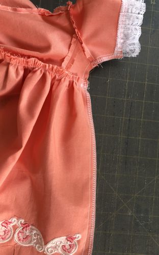 Photo shows the stitching from the sleeve hem to the skirt hem.