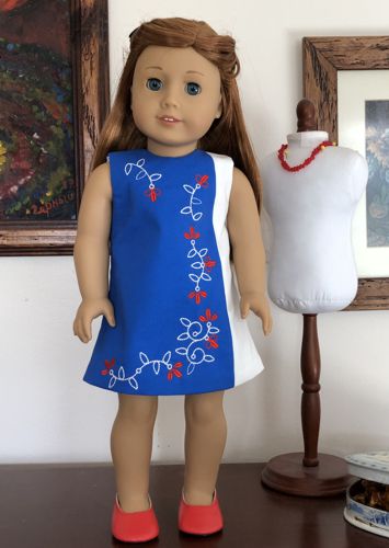 A doll in pink dress with embroidered organza overlay