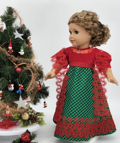 A doll in a finished dress with embroidery and lace shawl.