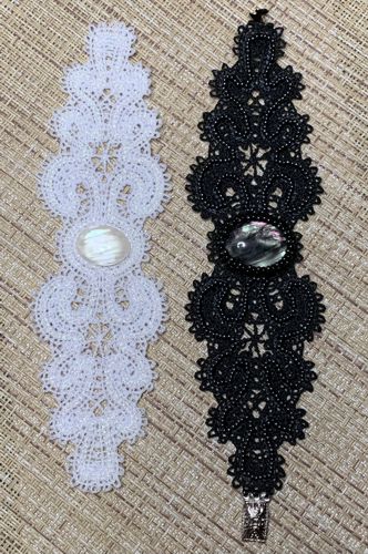 Stitch-outs of the bracelets - one in white, the other in black colors.