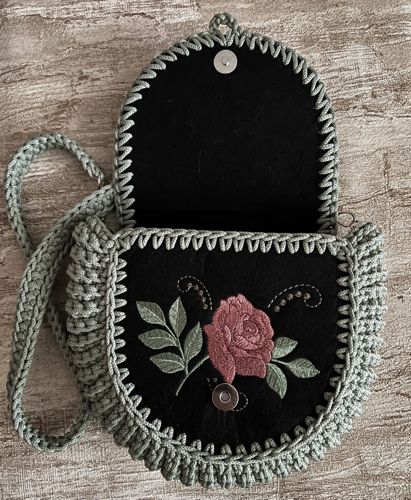 A bag camellia embroidery and crocheted black sides.