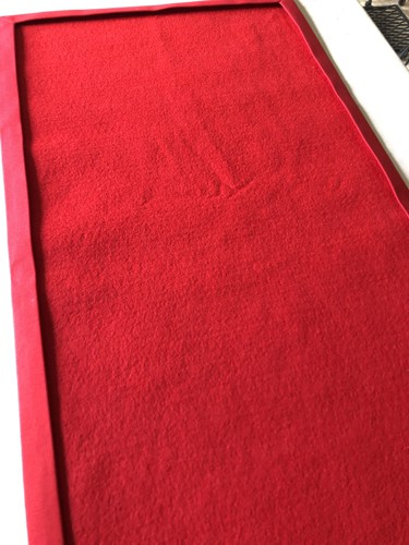 The lining inserted under the folded edges of the tablerunner.