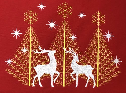 A close-up of the embroidery with deer and trees.