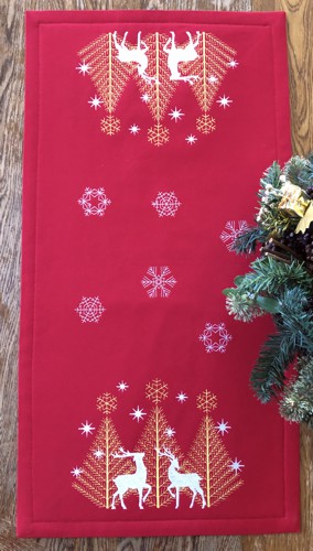 Finished red colored tablerunner with deer and snowflake embroidery