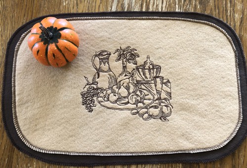 A finished felt placemat with embroidery.