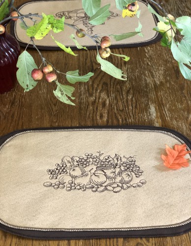 A finished felt placemat with embroidery.