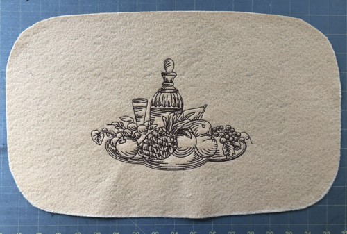 An embroidered piece with rounded corners.