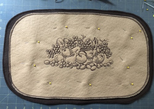 Embroidered piece pinned to the brown piece.