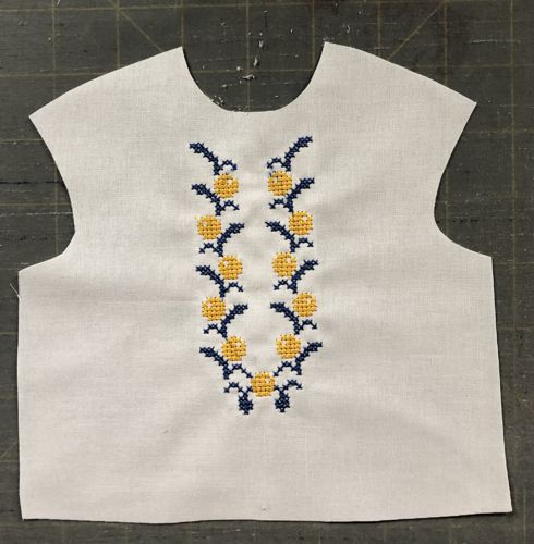 The cut-out front of the blouse with embroidery.