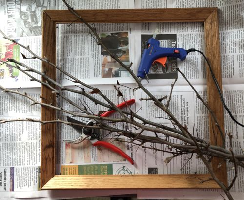 Picture frame, twigs, garden scissors, glue gun.
