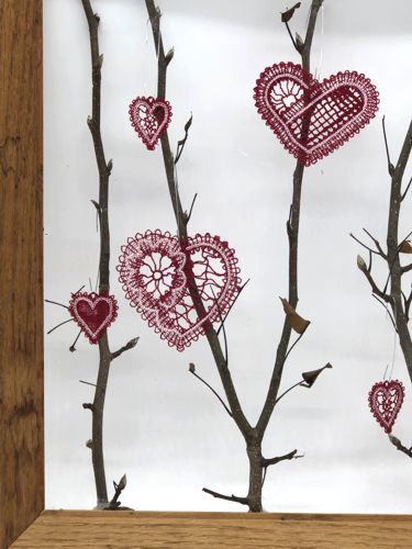 Close-up of the twigs in the frame with the heart ornaments.