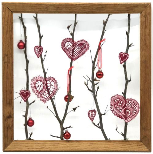 Finished project: picture frame with twigs and stitch-outs of the heart stitch-outs.